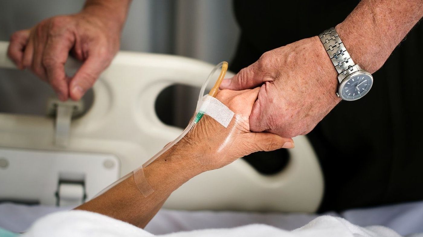 Manos sosteniendo la mano de una persona hospitalizada